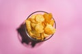 Potato chips on pink background in minimalism style. Flat lay