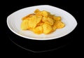 Potato chips on a plate on a black background