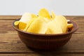 Potato chips in plate on wooden table isolated on grey background