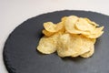 Potato chips on a round slate Royalty Free Stock Photo