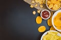 Potato chips and snacks on black slate table, top view Royalty Free Stock Photo