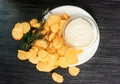 Potato chips with sprig of dill and bowl of sour cream on a white plate. Fast food. Rustic food background. Top view