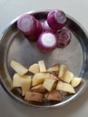 Potato cutting and onion in a steel dish.