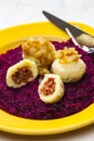 potato dumplings filled with smoked meat with fried onion on red cabbage Royalty Free Stock Photo