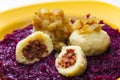 Potato dumplings filled with smoked meat with fried onion on red cabbage Royalty Free Stock Photo