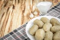 Potato dumplings with stuffed minced meat on a white plate and gravy boat with sour cream on wooden background Royalty Free Stock Photo