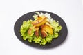 potato fried chips on a lettuce leaf, and a black ceramic plate, isolated on white Royalty Free Stock Photo