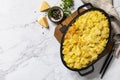Potato gratin, french cuisine. Healthy casserole or gratin with cream, gratin dauphinois on a gray stone table. Top view flat lay