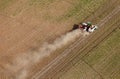 An aerial view of trucks and tractors harvesting potatoes.