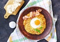 Potato hash brown with egg and bacon on a brown clay plate on a dark concrete background. American cuisine Royalty Free Stock Photo