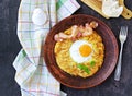 Potato hash brown with egg and bacon on a brown clay plate on a dark concrete background. American cuisine Royalty Free Stock Photo