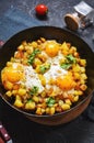 Potato hash with eggs and herbs for breakfast on black stone background Royalty Free Stock Photo