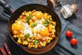 Potato hash with eggs and herbs for breakfast on black stone background Royalty Free Stock Photo