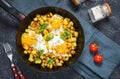 Potato hash with eggs and herbs for breakfast on black stone background Royalty Free Stock Photo