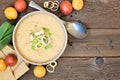 Potato and leek soup, above view table scene on rustic wood with copy space Royalty Free Stock Photo