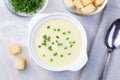 Potato leek soup in a white ceramic bowl garnished with green onion served with croutons, horizontal, top view Royalty Free Stock Photo