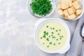 Potato leek soup in white ceramic bowl garnished with green onion, served with croutons,  top view,  horizontal, copy space Royalty Free Stock Photo