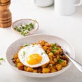 Potato, onion and ham hash topped with fried egg Royalty Free Stock Photo