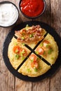 potato pancakes with bacon, tomatoes, onions and sauces close-up. Vertical top view Royalty Free Stock Photo