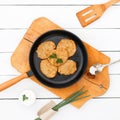 Potato pancakes on a cast-iron frying pan on a tray on a white Royalty Free Stock Photo