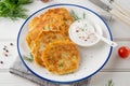 Potato pancakes, latkes or draniki with fresh herbs and sour cream on a plate on a white wooden background. Top view, copy space Royalty Free Stock Photo