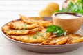 Potato pancakes or latkes or draniki with sour cream in plate on white wooden table Royalty Free Stock Photo