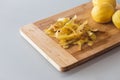 Potato peelings with potatoes on wooden cutting board on grey background