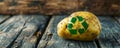 Potato with a recycle symbol imprint on wooden surface