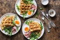 Potato savory waffles with boiled egg, ham and arugula on wooden background, top view. Served breakfast, snack, brunch.