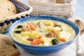 Potato soup with turkey and zucchini on wooden table.