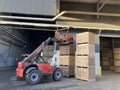 Potato storage facility. Forklift used to stack the crates. Refrigerated cold warehouse for potatoes and onions with wooden boxes. Royalty Free Stock Photo