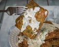 Potato waffles with creamy cheese sauce with herbs, waffle on a fork close-up Royalty Free Stock Photo