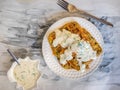 Potato waffles on a white plate with a fork and cheese sauce in a freestanding saucepan on a black and white napkin Royalty Free Stock Photo