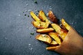 Potato wedges with sea salt and herbs in a paper bag Royalty Free Stock Photo