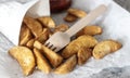 Potato wedges with wooden fork and tomato sauce