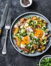 Potatoes, bacon, eggs breakfast baked hash on a dark background, top view. Delicious breakfast, snack, brunch