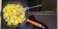 Potatoes cut into thin slices are fried in a pan, some pieces are already well fried