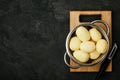 Potatoes. Fresh raw peeled potatoes in colander on dark stone background. Top view,  copy space Royalty Free Stock Photo