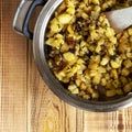 Potatoes fried with garlic and herbs, served in a apen, wooden background