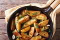 Potatoes fried in a pan, horizontal top view closeup, rustic