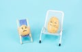 Potatoes with funny faces sitting in lounge chairs and having a conversation, the small one is sad, the big one smiles Royalty Free Stock Photo