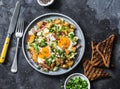 Potatoes, ham, eggs breakfast hash on a dark background, top view. Delicious, nutritious breakfast, snack