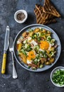 Potatoes, ham, eggs breakfast hash on a dark background, top view. Delicious, nutritious breakfast, snack