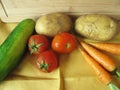 Potatoes, orange carrots, zucchini and red fresh tomatoes on yellow tablecloth Royalty Free Stock Photo