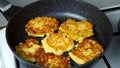 Potatoes pancakes, draniki cooking in frying pan on gas oven on kitchen.