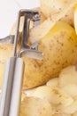 Potatoes with Peeler and Peeled Skin Royalty Free Stock Photo