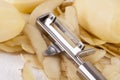 Potatoes with Peeler and Peeled Skin Royalty Free Stock Photo