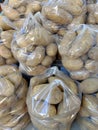 Potatoes in plastic bags stocked for sale.