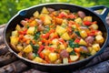 potatoes and sausage meal cooked in a cast-iron skillet