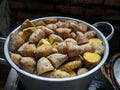 Potatoes with their skins in a stainless steel pot. ripe yam, visible smoke.